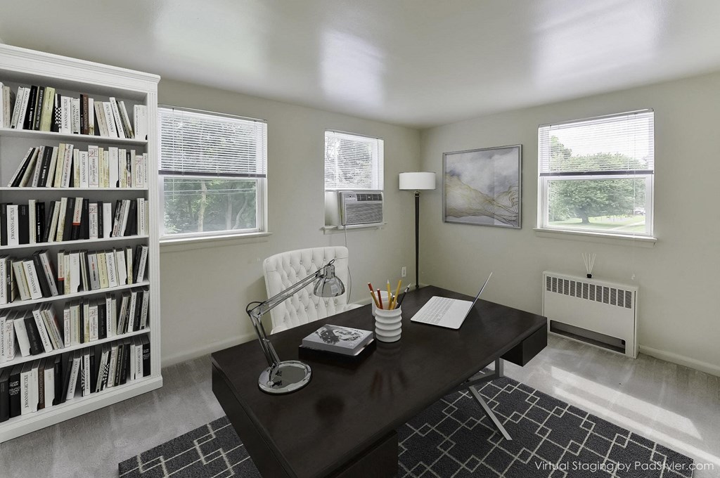 a home office with a desk and a bookshelf