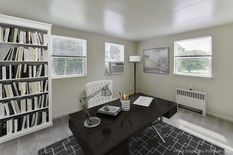 a home office with a desk and a bookshelf