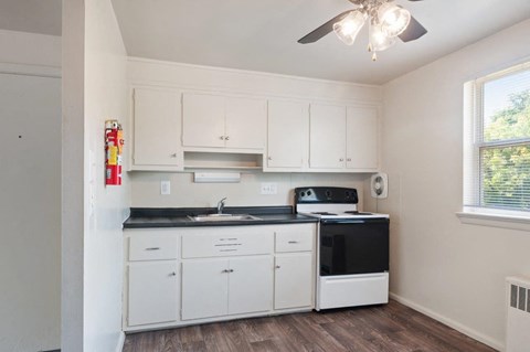 a kitchen with white cabinets and a black counter top
