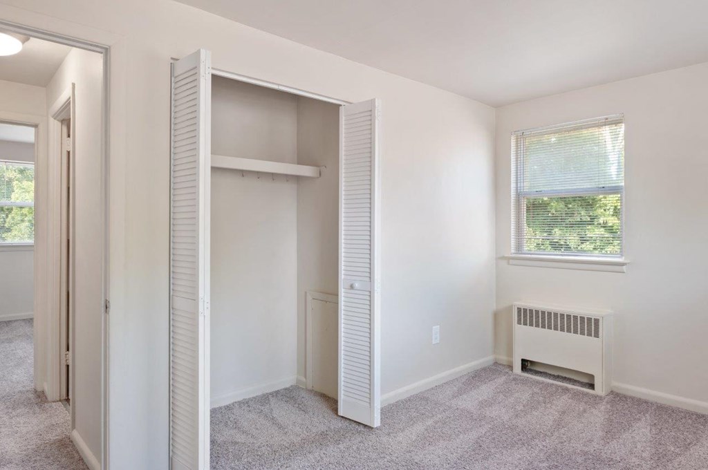 a bedroom with a closet and a window