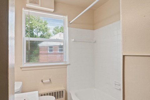a bathroom with a window and a toilet and a sink