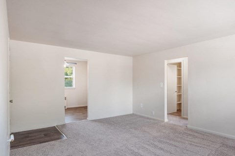 an empty living room with white walls and a carpet