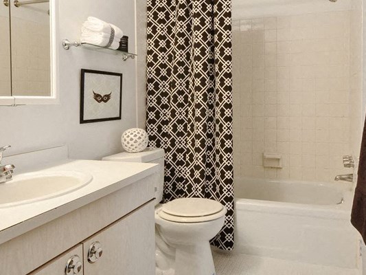 a white bathroom with a black and white shower curtain