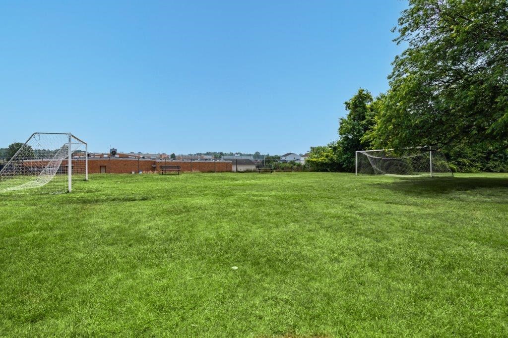 a soccer field with a net and a brick building in the background