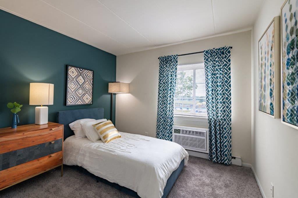 a bedroom with a bed and a window with curtains