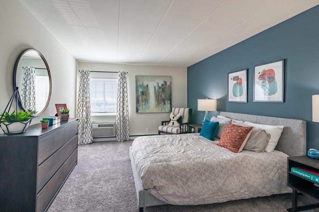 a bedroom with a bed and a dresser and a window