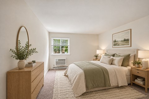 A bedroom with a large bed and a window with a view of trees.