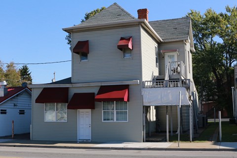 a white house with red awnings on a street