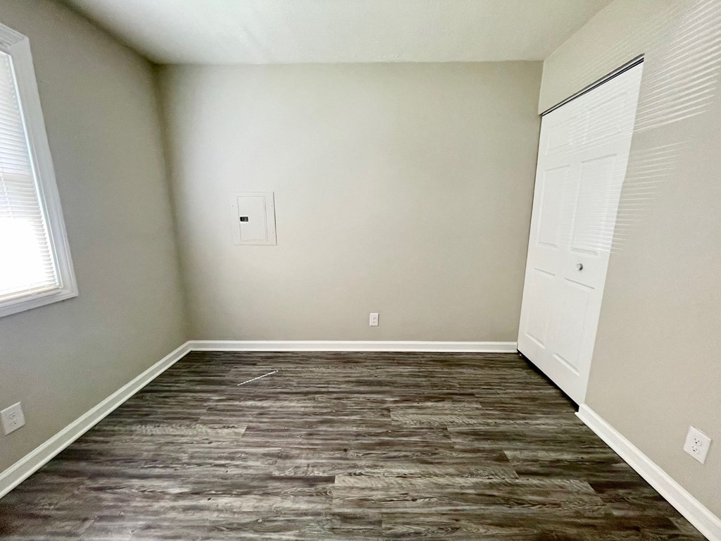 an empty room with wood flooring and white doors
