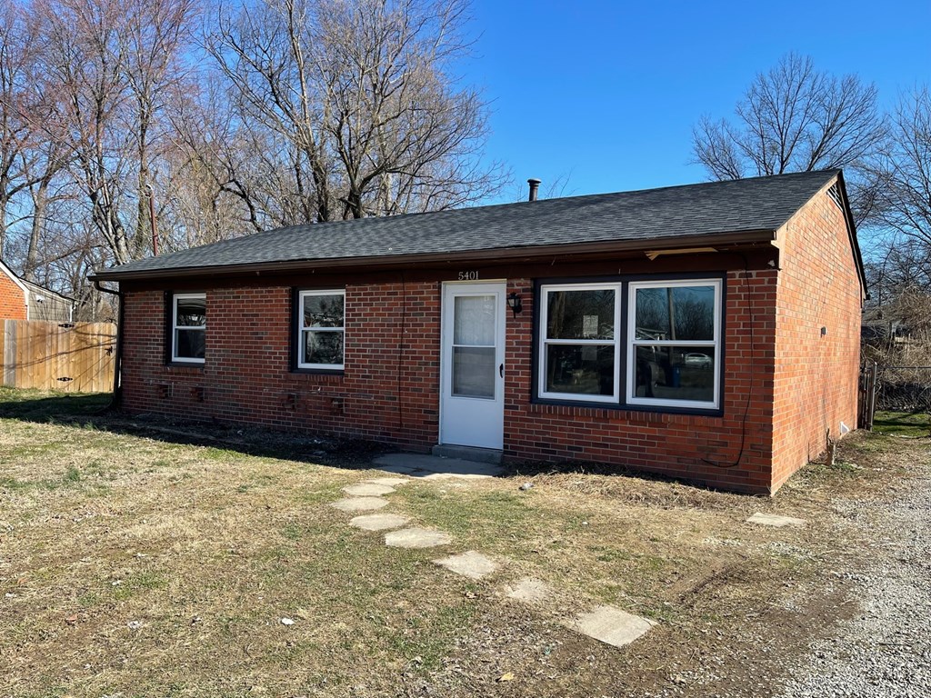 a small brick house with a white door and windows