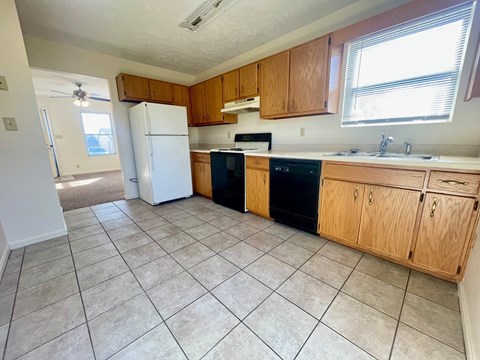 an empty kitchen with a refrigerator and a sink