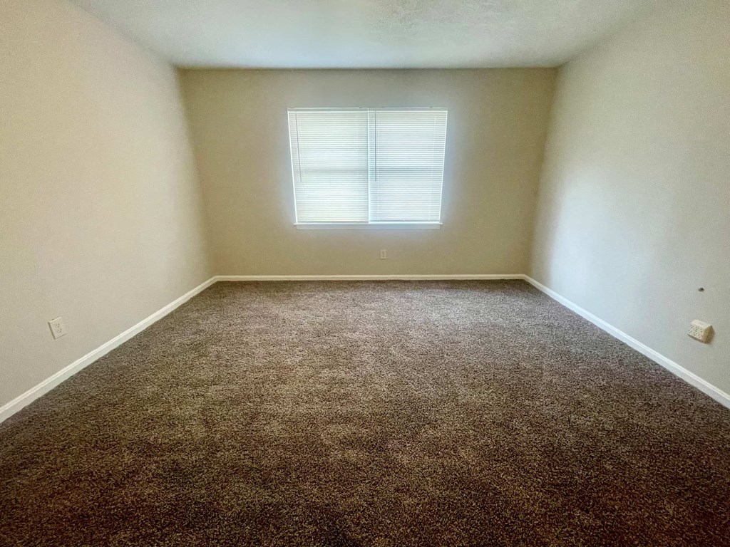 an empty room with carpet and a window