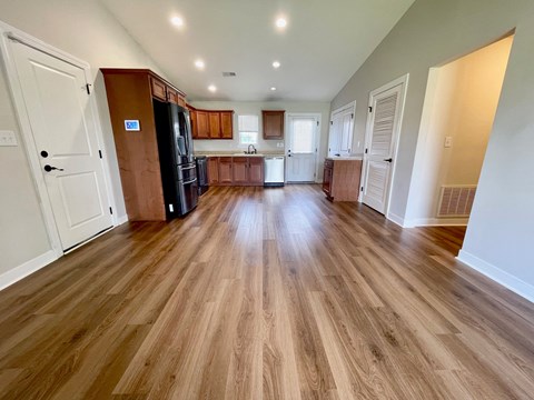 a kitchen and living room with wood flooring in a new home
