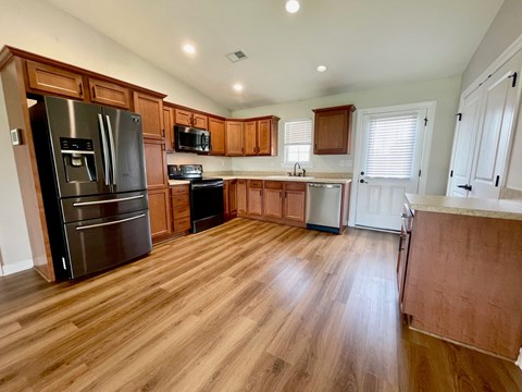 a kitchen with wooden floors and stainless steel appliances