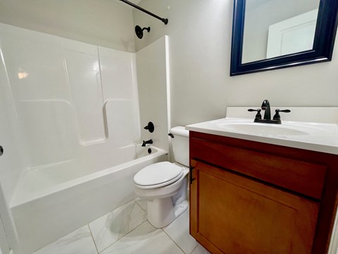 a bathroom with a toilet and a sink and a bath tub