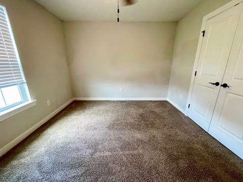 an empty room with carpet and white doors