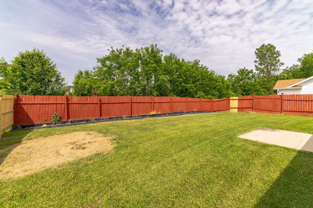 a backyard with a fenced in yard and a wooden fence