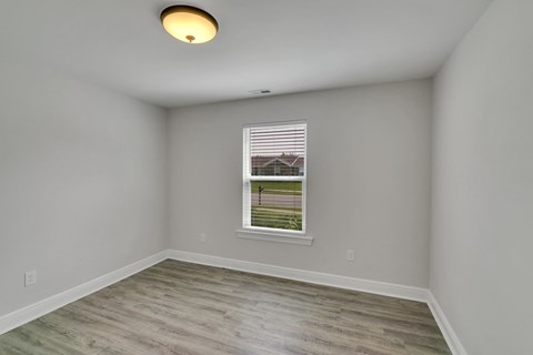 an empty room with white walls and a window