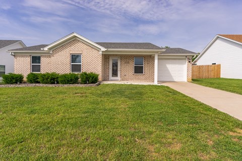 a brick house with a sidewalk in front of it