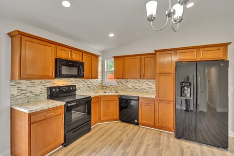 a kitchen with wooden cabinets and a black refrigerator
