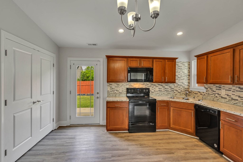 a kitchen with wooden cabinets and black appliances