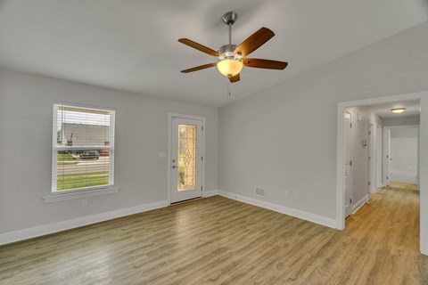 a living room with wood floors and a ceiling fan