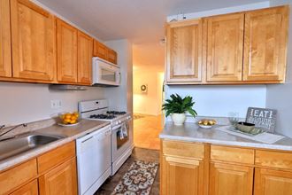 a kitchen with white appliances and wooden cabinets