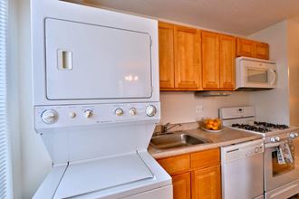 a kitchen with white appliances and wooden cabinets