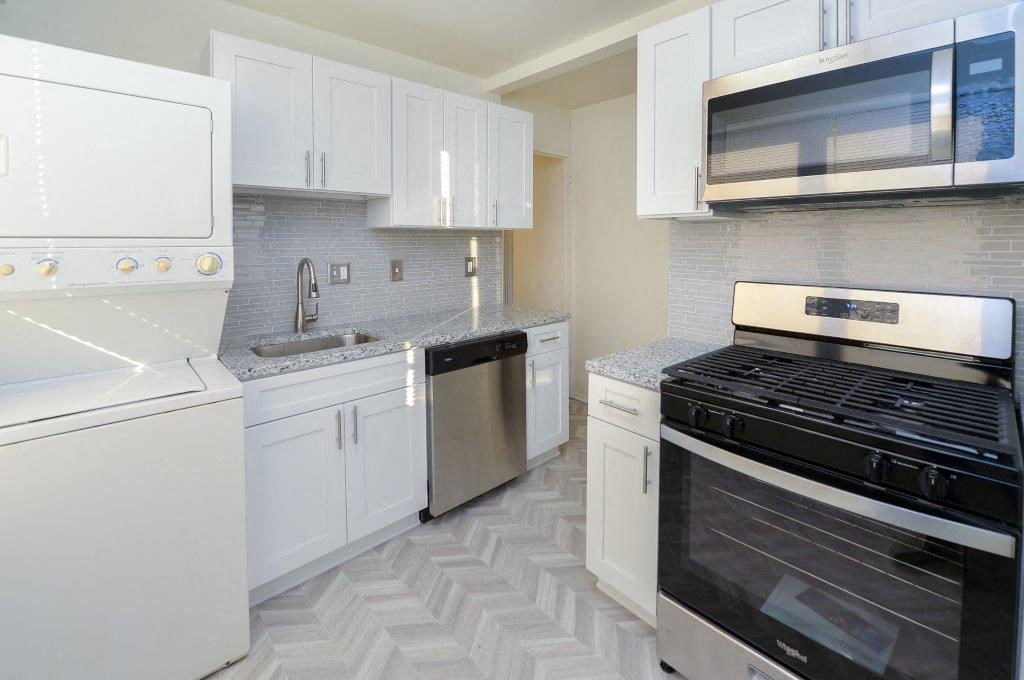 a white kitchen with a stove and a microwave