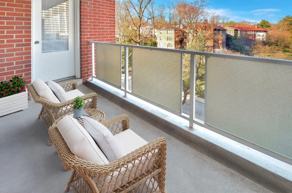 a balcony with wicker furniture and a brick wall