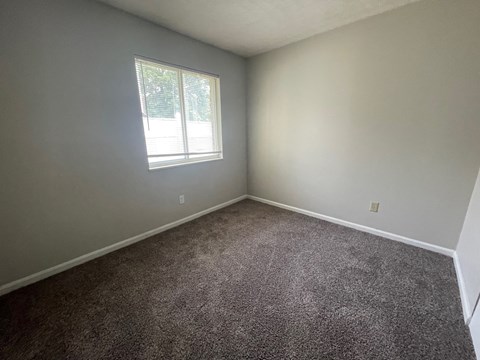 an empty room with carpet and a window