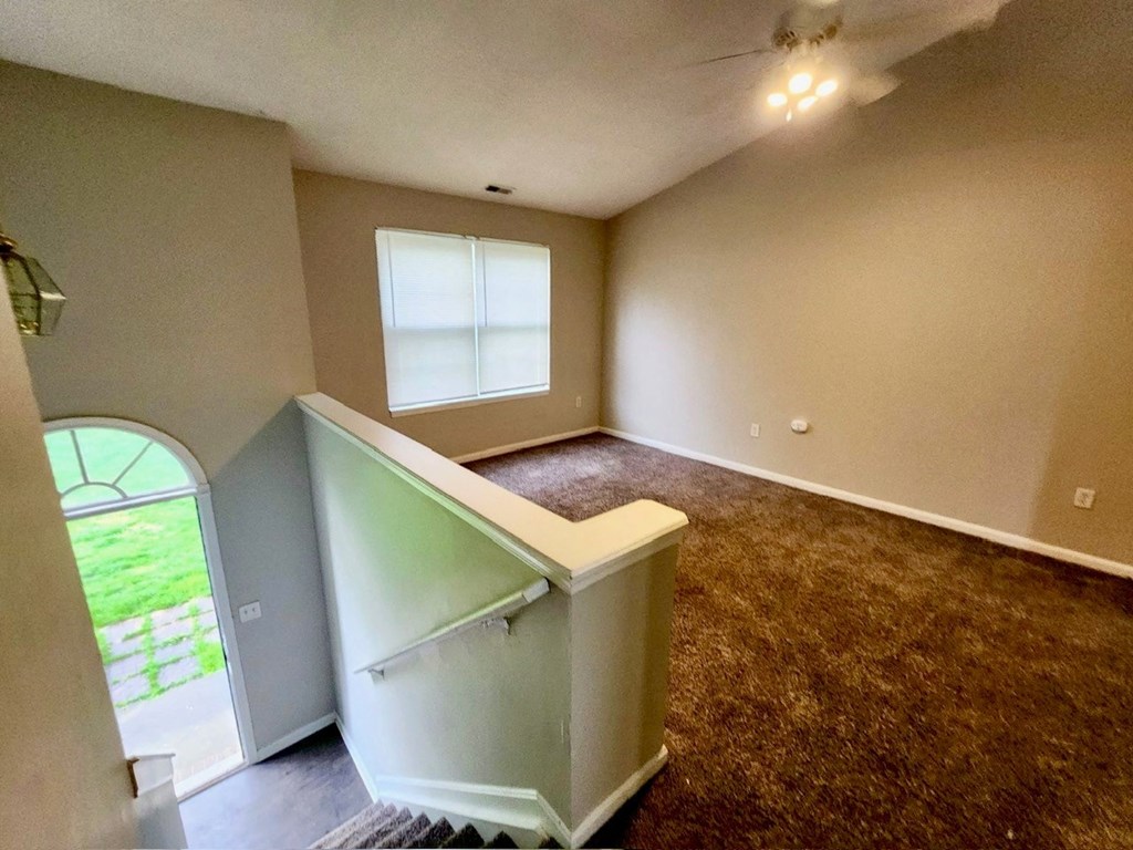 an empty living room with a couch and a window
