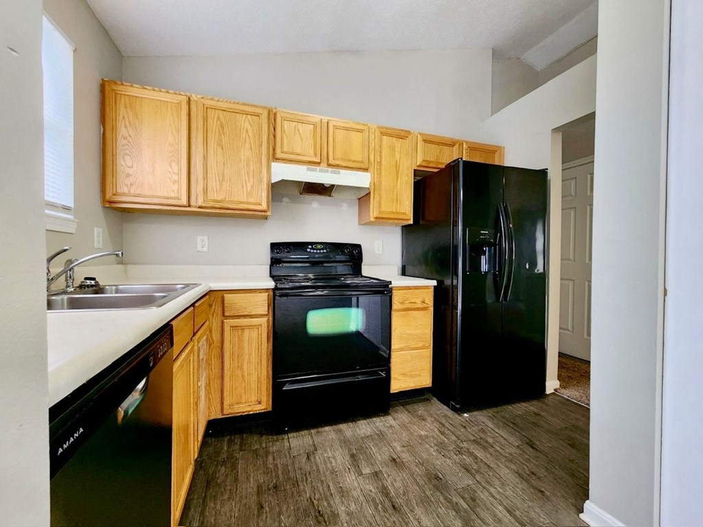 a kitchen with black appliances and wooden cabinets