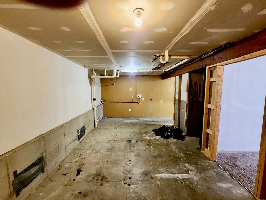 a room in the process of being remodeled with a door open and dirty floors