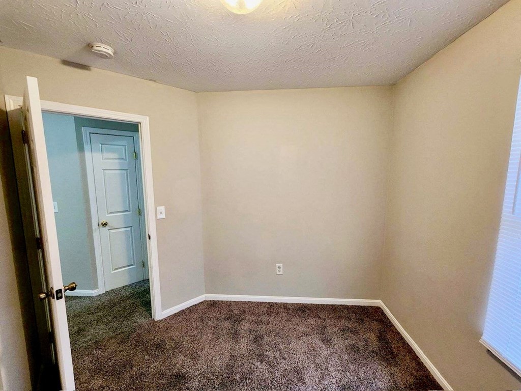 a room with a carpeted floor and a door