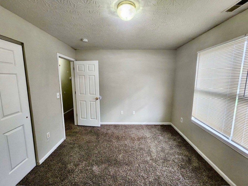 a room with a carpeted floor and a white door
