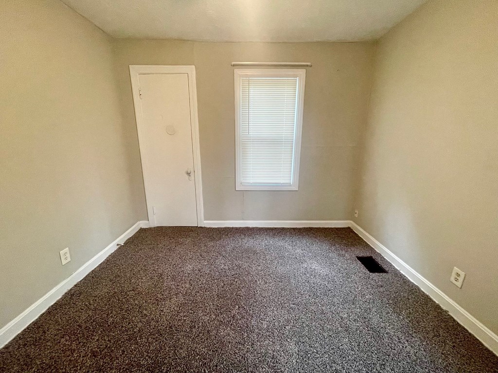 a empty room with carpet and a window