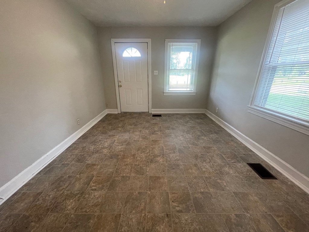 an empty room with tile flooring and a white door