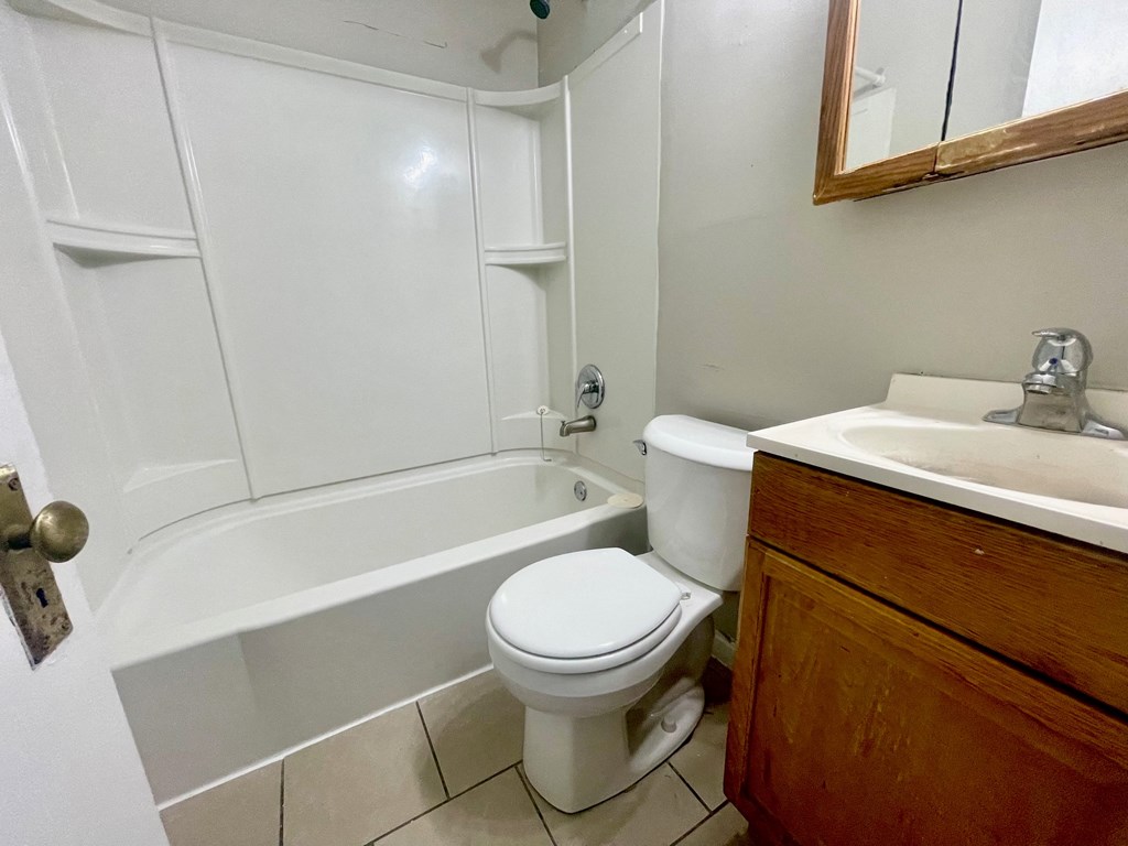 a bathroom with a toilet and a tub and a sink