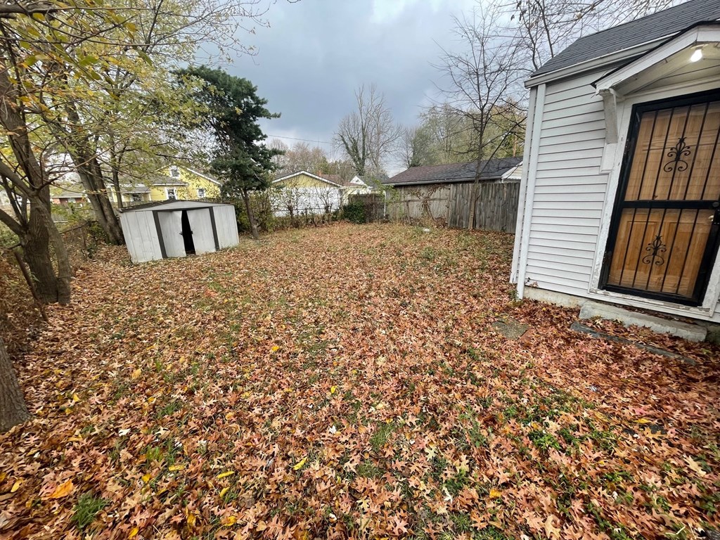 a yard with fallen leaves in front of a house