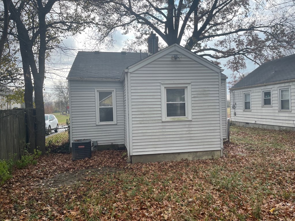 a small white house in a yard with some trees