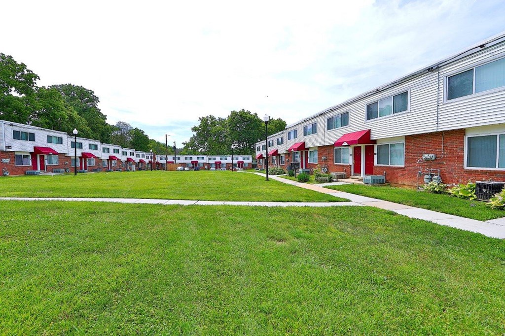 a row of houses with green grass and sidewalks