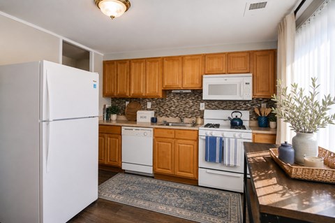 A kitchen with wooden cabinets and white appliances.