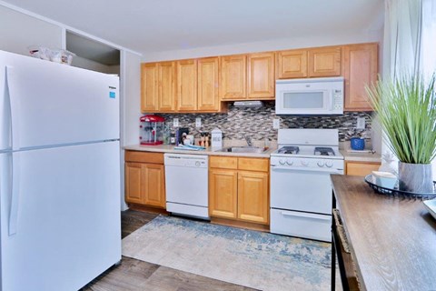 a kitchen with white appliances and wooden cabinets