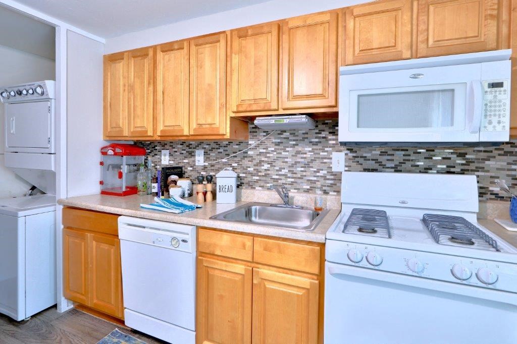 a kitchen with white appliances and wooden cabinets