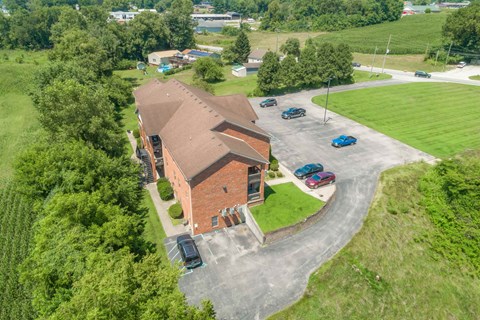 an aerial view of a church with a brick building and a parking lot