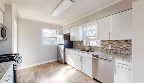 a kitchen with white cabinets and a stainless steel refrigerator