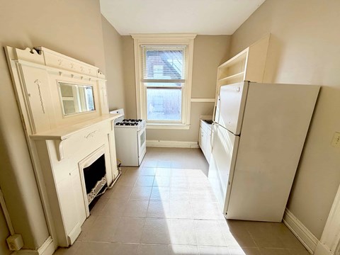 A kitchen with a white stove top oven and a white refrigerator.