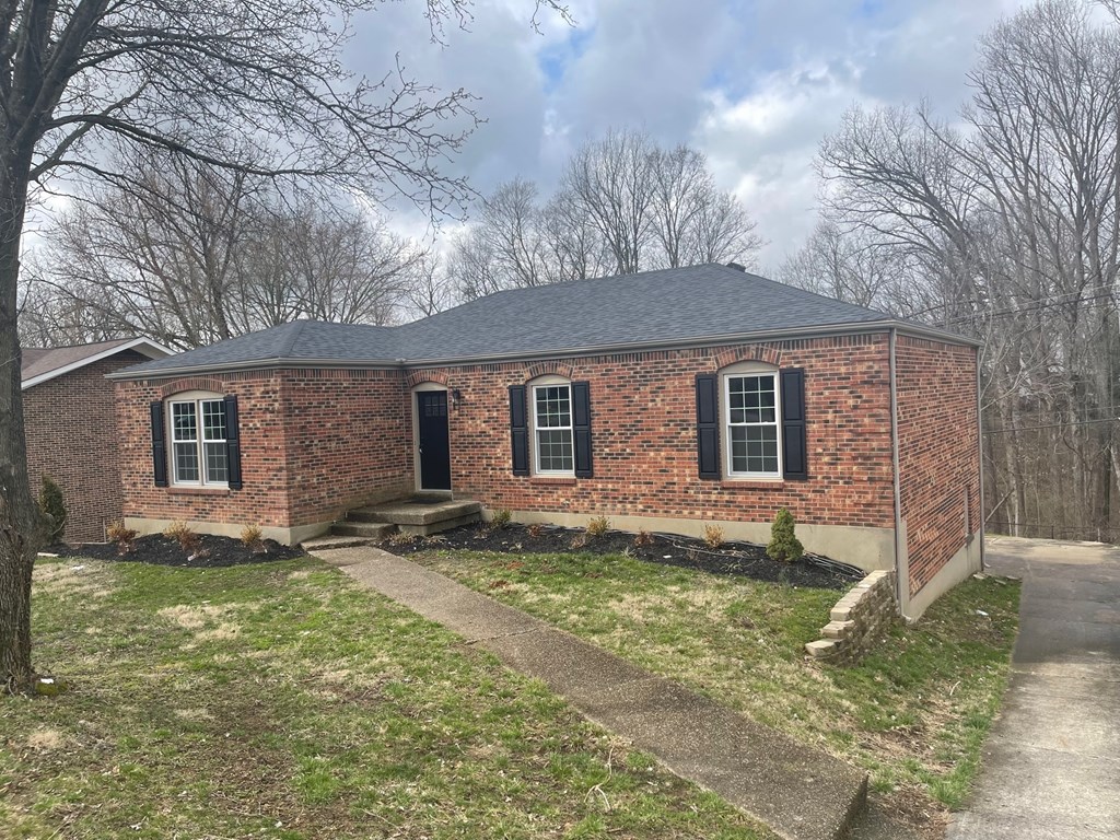 A small brick house with a black door and windows.