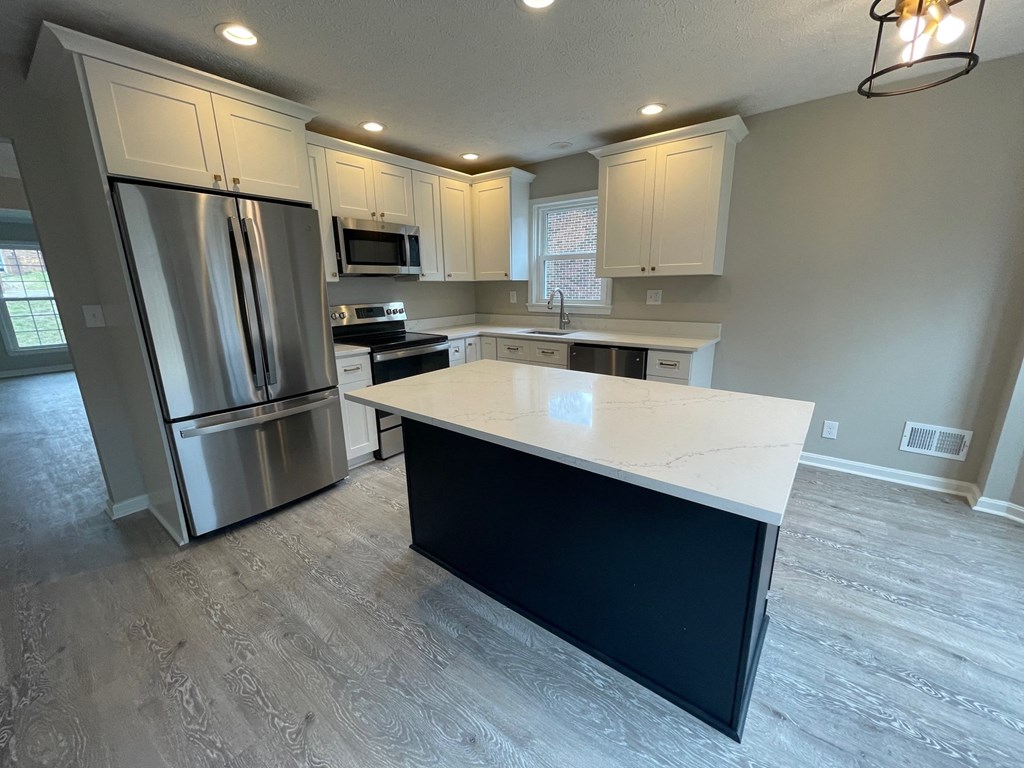 A kitchen with a white countertop and stainless steel appliances.